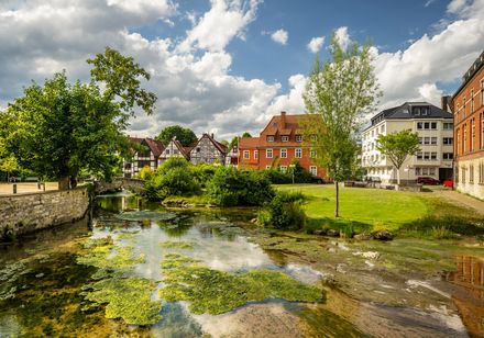 Dielenpaderquellgebiet: Wasser der Pader, dahinter Häuser mit Fachwerk und bunter Fassade