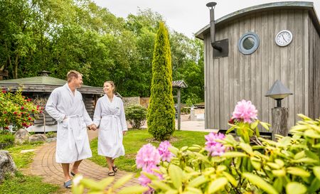 Ein Paar im Bademantel spaziert durch den Saunagarten der Driburg Therme in Bad Driburg.