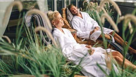 Zwei Personen im Bademantel liegen entspannt im Outdoor-Bereich vom Ishara Bielefeld