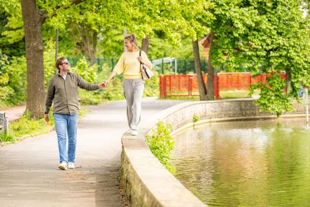 Zwei Personen am Wasser im Steinmeisterpark Bünde, eine Person balanciert auf Mauer