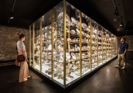 Museumsausstellung im Schloss Fürstenberg mit vielfältigen Porzellanobjekten, Besucher betrachten Vitrine.