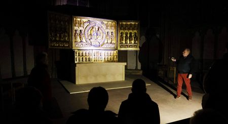 Mann leuchtet auf kunstvollen Altar bei Taschenlampenführung im Mindener Dom