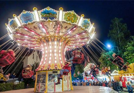 Rundfahrgeschäft im nostalgischen Stil, geschäftiger Zwiebelmarkt bei Nacht mit fröhlichen Besuchern.