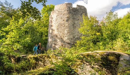 Wanderer mit Rucksack vor der Iburg in Bad Driburg