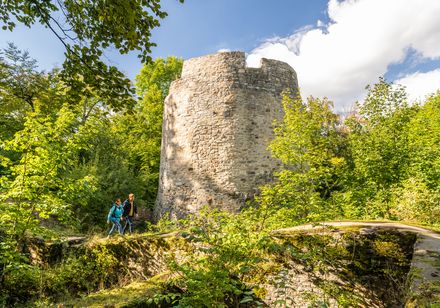 Wanderer mit Rucksack vor der Iburg in Bad Driburg