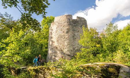 Wanderer mit Rucksack vor der Iburg in Bad Driburg