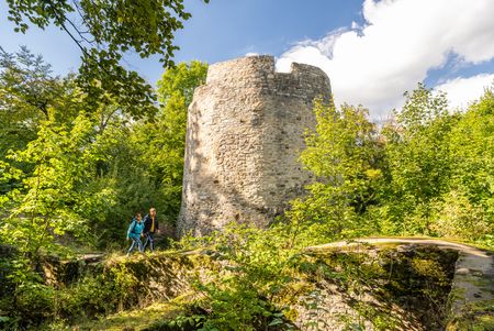 Wanderer mit Rucksack vor der Iburg in Bad Driburg