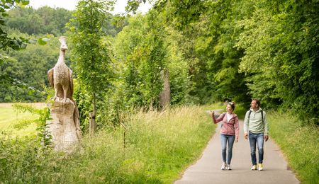 Spaziergänger beim Haxtergrund, links Holzfigur eines Vogels