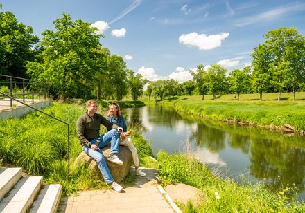 Zwei Personen machen Pause an Treppenstufen im Werreauenpark Löhne
