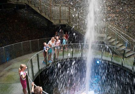 Personen stehen im begehbaren Wasserkrater im Aqua Magica Park