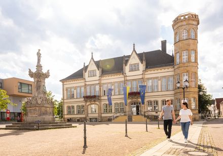 Historisches Rathaus Horn-Bad Meinberg mit markantem Turm und barocker Sandsteinfigur im Vordergrund.