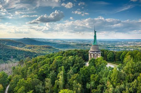 Hermannsdenkmal umgeben von Wäldern mit weitem Blick über das lippische Bergland und blauen Himmel.