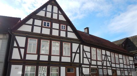 Fachwerkhaus mit weißen Wänden, Tourist-Info und Galerie in Schwalenberg unter blauem Himmel.