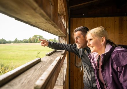 Zwei Personen schauen aus Vogelbeobachtungsplattform in Versmold