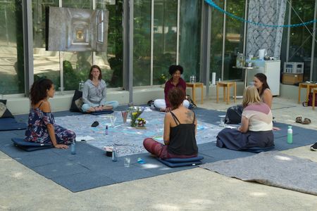 Gruppe meditiert im Glashaus