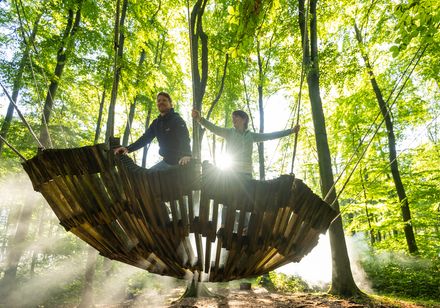 Zwei Personen auf hägendem Kunstobjekt - Nieheimer Kunstpfad