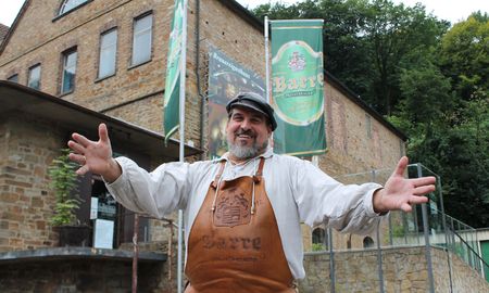 Person steht mit offenen Armen vor Barres Brauwelt