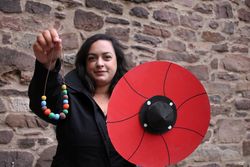 Frau zeigt Schild und Perlenkette