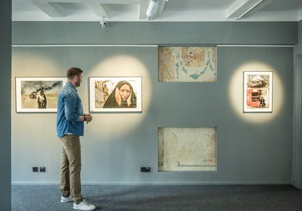 Mann betrachtet Fotos im Forum Anja Niedringhaus