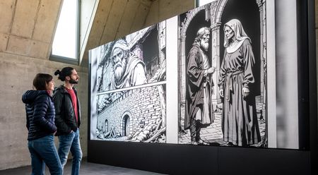 Zwei Personen betrachten schwarz-weiß-Bild im Archäologischen Fenster am Münster