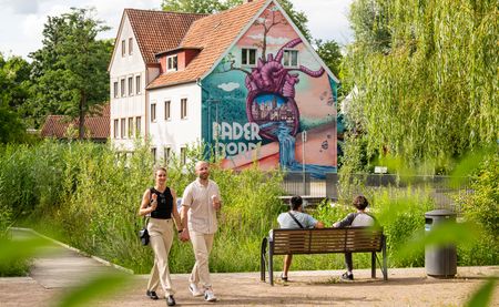 Personen spazieren vor dem Herzgraffiti