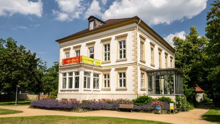 Außenansicht Museum Huelsmann in Bielefeld mit eindrucksvoller Fassade und Blumenbeeten