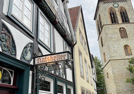 Fachwerkfassade, rechts ein Kirchturm