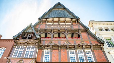 Verzierte Hausfassade des Haus Schmieding mit Figurenspiel der Minden-Saga