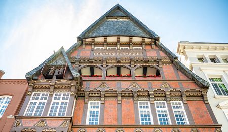 Verzierte Hausfassade des Haus Schmieding mit Figurenspiel der Minden-Saga