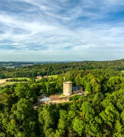 Luftaufnahme der mittelalterlichen Burg Ravensberg im Teutoburger Wald, umgeben von dichten Wäldern.