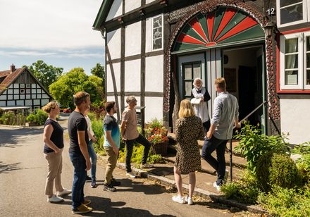 Gruppe steht vor dem Hauseingang eines Fachwerkhauses