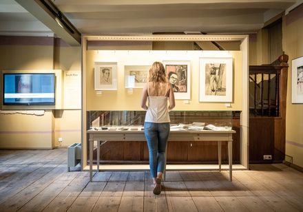 Frau schaut in Vitrine in Forum Jacob Pins