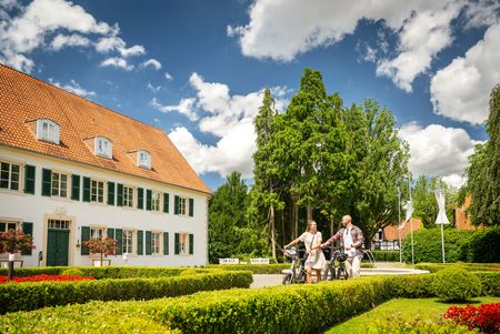 Zwei Personen gehen mit Fahrrädern durch den Kurpark Bad Holzhausen