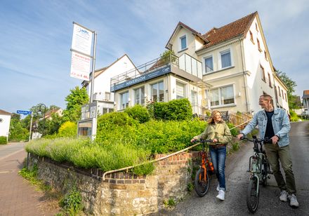 Zwei Radfahrer schieben ihre Räder entlang der Mauer des Wander- und Fahrradhotels Havergoh