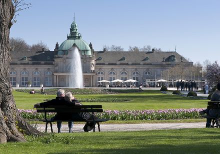 Außenaufnahme vom Kaiserpalais Bad Oeynhausen mit Springbrunnen und Paar im Vordergrund