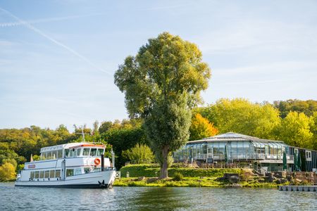 Weißes Ausflugsschiff auf dem Schiedersee, umgeben von grünen Bäumen
