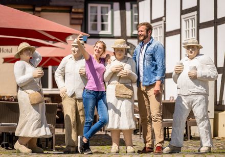 Ein Paar macht ein Selfie vor lebensgroßen Figuren in Rheda-Wiedenbrück