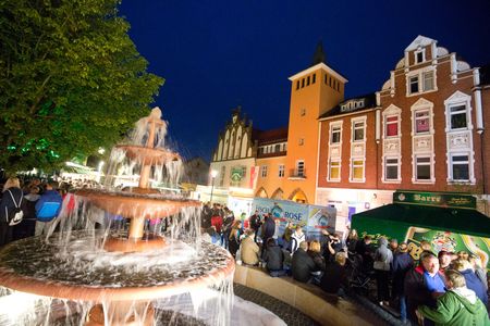 Bierbrunnenfest in Lübbecke: Brunnen, Bierwagen und im Hintergrund beleuchtete Gebäude