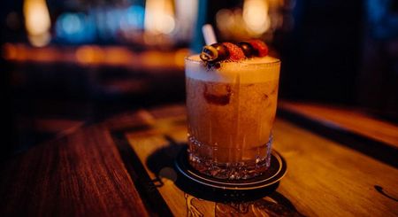 Cocktail in einem Glas auf einer Holztheke