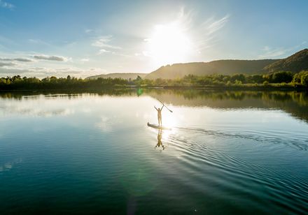 Person beim Stand Up Paddling auf dem Godelheimer See im Kulturland Kreis Höxter