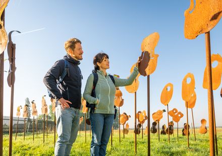 Zwei Personen schauen sich Metall Kunstwerke auf dem Nieheimer Kunstpfad an