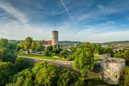 Die Sparrenburg in Bielefeld thront majestätisch auf einem bewaldeten Hügel unter blauem Himmel.