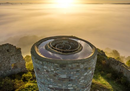 Der Südturm von Burgruine Kürnberg erhebt sich majestätisch über einer Nebeldecke im Sonnenaufgang.