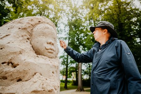 Mann erstellt Sandfigur
