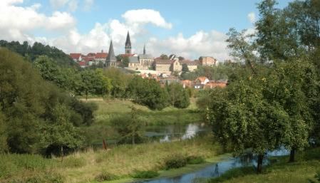 Blick auf die historische Stadt Warburg mit markanten Kirchtürmen und umgeben von grüner Natur.