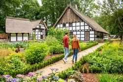 Paar geht durch Garten beim Museumshof Rahden