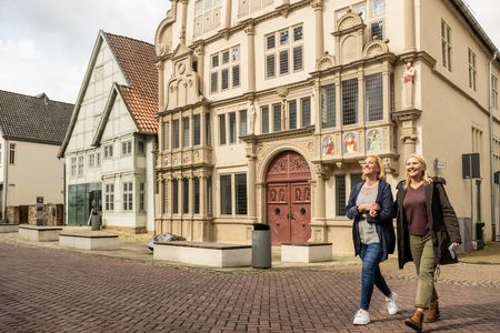 Zwei Frauen gehen entlang des Hexenbürgermeister Hauses in Lemgo