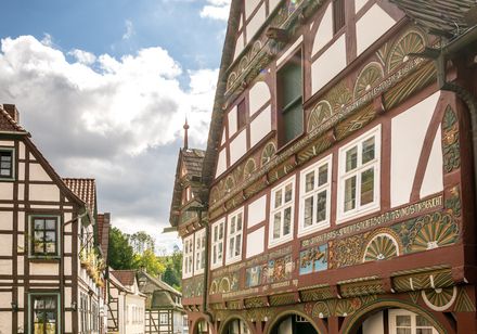 Historische Fachwerkhäuser in Schieder-Schwalenberg in sonniger Gasse, verziert mit bunten Malereien und Holzornamenten.