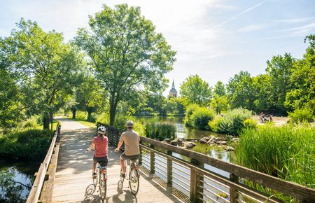 Zwei Radfahrer fahren auf Brück am Emssee in Rheda-Wiedenbrück