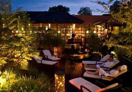 Entspannte Abendstimmung in der Bali Therme mit beleuchtetem Außenbereich und komfortablen Liegen.